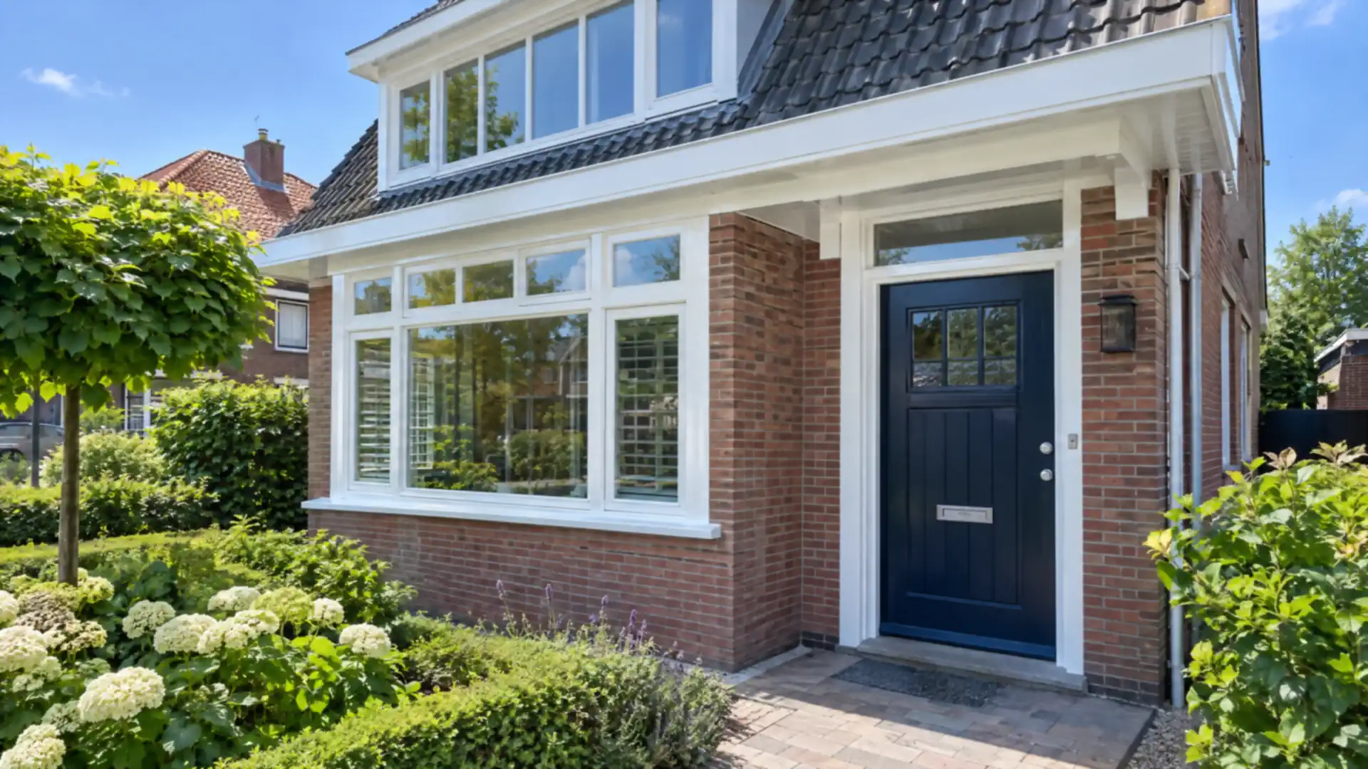 Buitenschilderwerk in Alkmaar: nieuw geschilderde witte kozijnen en donkerblauwe voordeur van een bakstenen woning