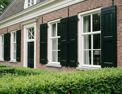 Vers geschilderde witte kozijnen aan de bakstenen gevel van een landhuis